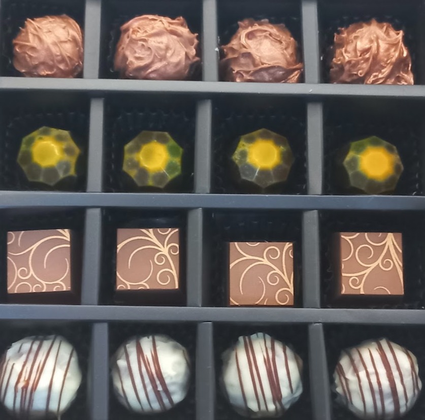 Schwarze Schachtel mit 4 Sorten Pralinen